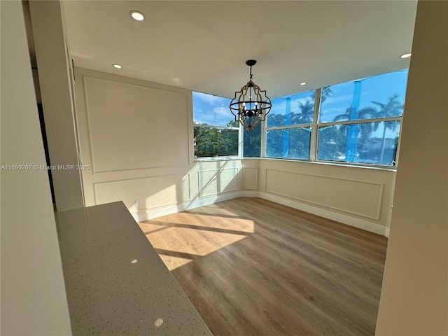 16546 NE 26th Ave Unit 3G, North Miami Beach, FL 33160 - unfurnished dining area with wood finished floors, recessed lighting, a chandelier, and a decorative wall