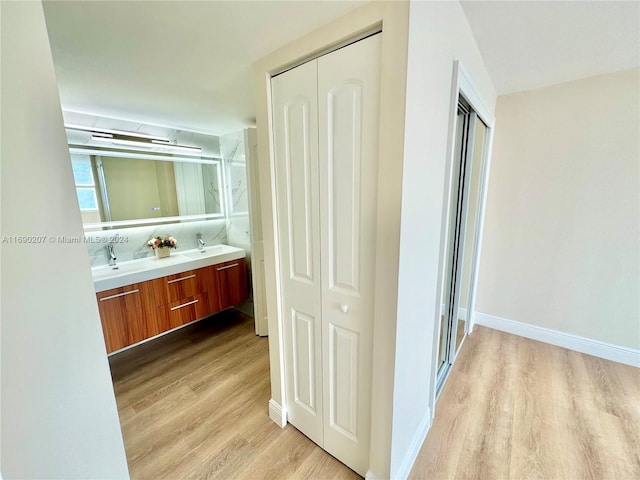 hallway with sink and light hardwood / wood-style flooring