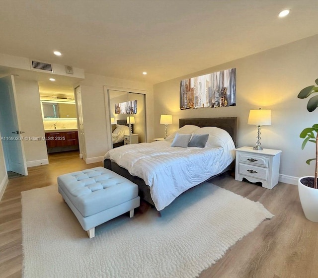 16546 NE 26th Ave Unit 3G, North Miami Beach, FL 33160 - bedroom featuring wood finished floors, a closet, recessed lighting, and ensuite bath