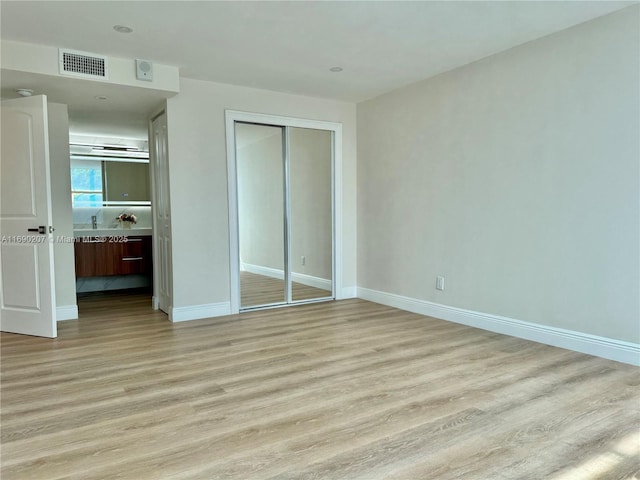 16546 NE 26th Ave Unit 3G, North Miami Beach, FL 33160 - unfurnished bedroom with light wood finished floors, a closet, and connected bathroom