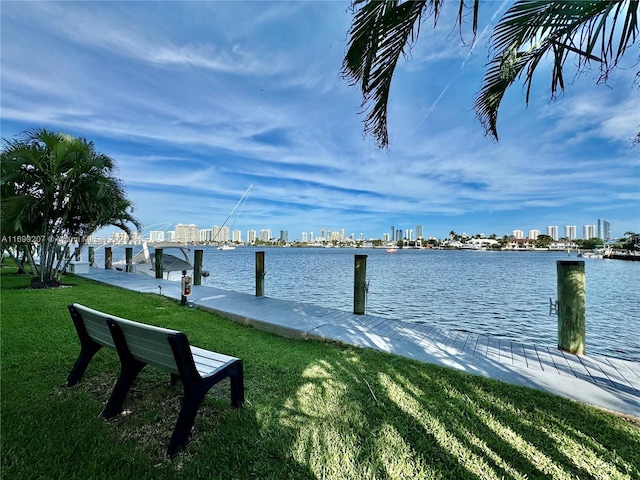 view of dock featuring a water view and a yard