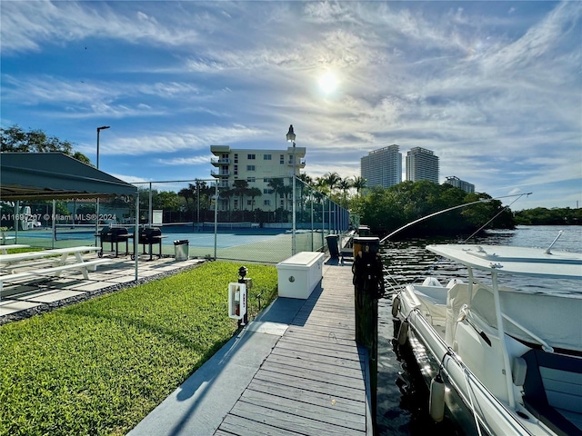 view of dock with a water view and a yard