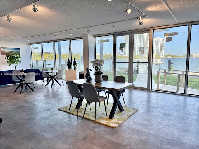16546 NE 26th Ave Unit 3G, North Miami Beach, FL 33160 - dining room with rail lighting, a textured ceiling, floor to ceiling windows, and a water view