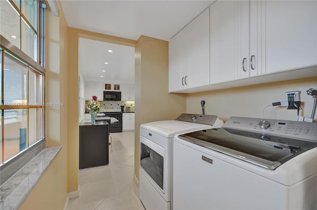 laundry room with cabinets, separate washer and dryer, a healthy amount of sunlight, and light tile patterned floors