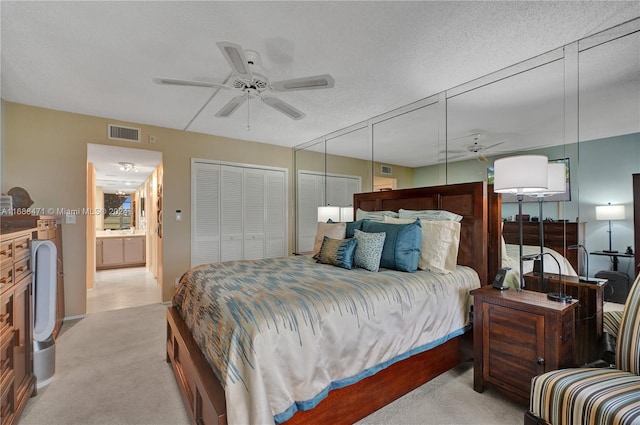 carpeted bedroom with ceiling fan and a textured ceiling