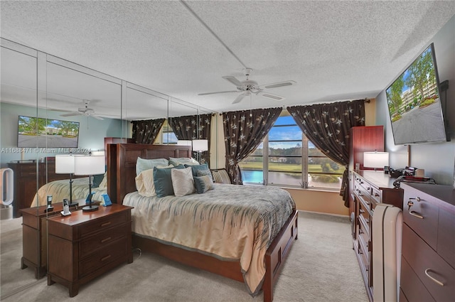 bedroom with light colored carpet, a textured ceiling, and ceiling fan