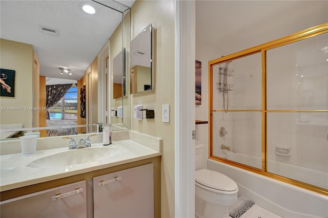 full bathroom featuring bath / shower combo with glass door, vanity, toilet, and tile patterned flooring