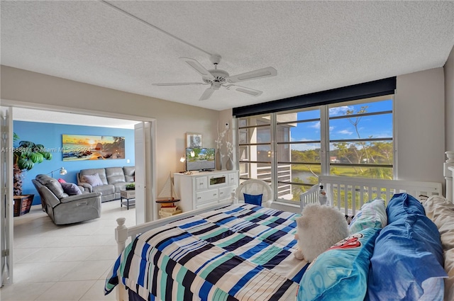 bedroom with ceiling fan, a textured ceiling, and light tile patterned floors