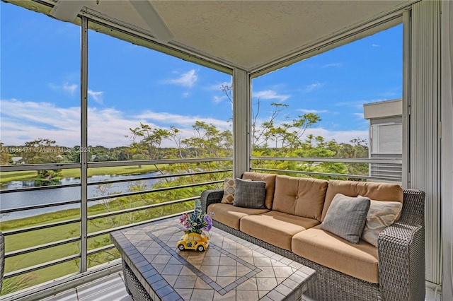 sunroom / solarium featuring a water view