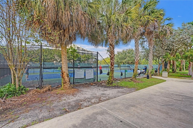 view of community with tennis court and a water view