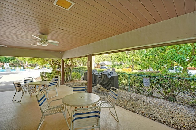 view of patio with ceiling fan and a pool