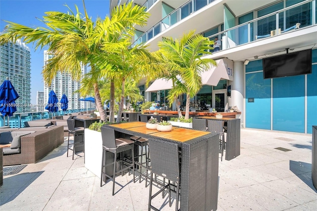 view of patio / terrace featuring exterior bar and a balcony