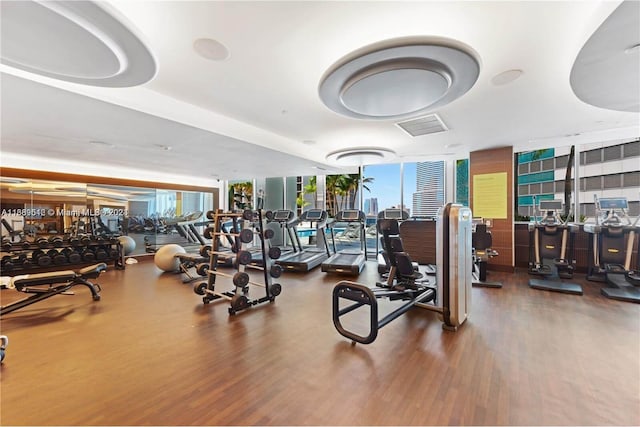 workout area with dark wood-type flooring and expansive windows