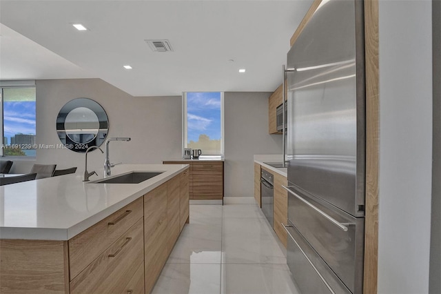 kitchen with a kitchen island with sink, black appliances, and sink