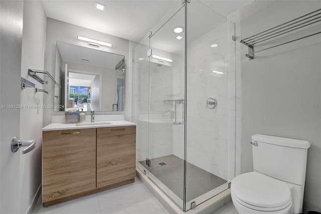 bathroom featuring toilet, vanity, and a shower with door