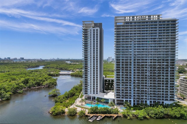 view of building exterior featuring a water view and a community pool