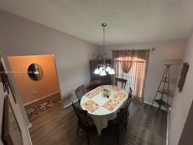 dining space with a notable chandelier, vaulted ceiling, dark hardwood / wood-style floors, and a textured ceiling