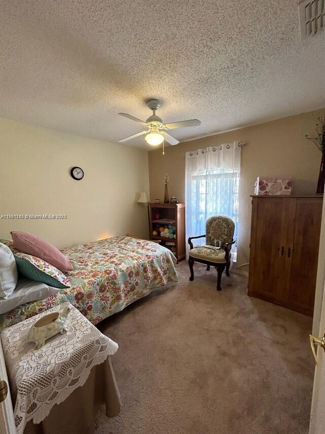 carpeted bedroom with a textured ceiling and ceiling fan