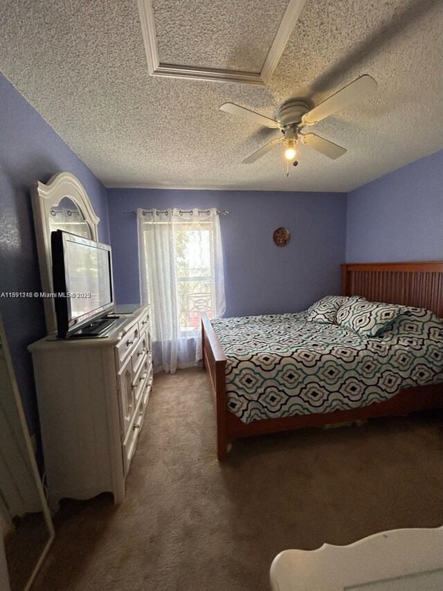 carpeted bedroom featuring ceiling fan and a textured ceiling