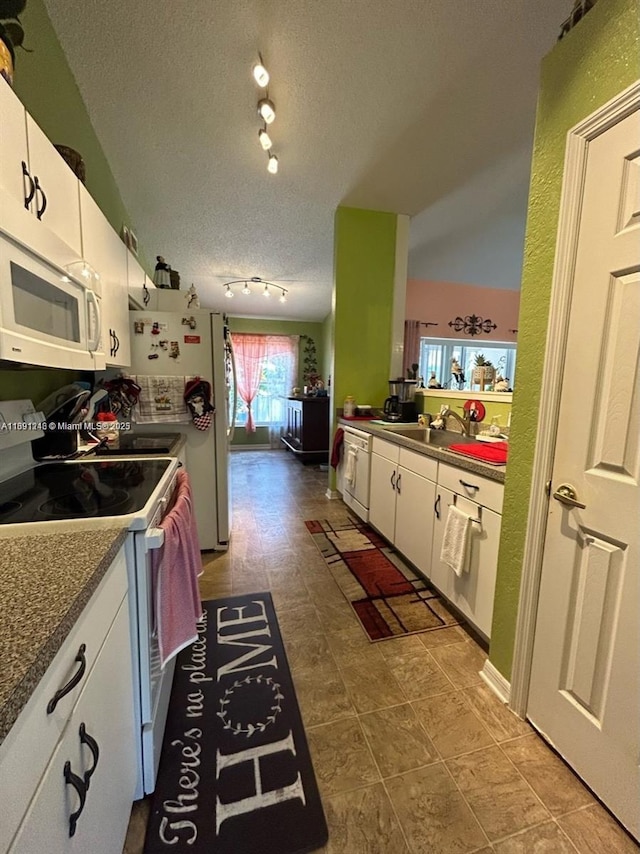 kitchen featuring sink, a textured ceiling, white cabinets, and white appliances