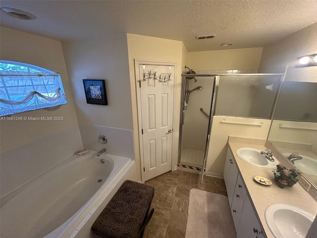 bathroom with vanity, shower with separate bathtub, and a textured ceiling