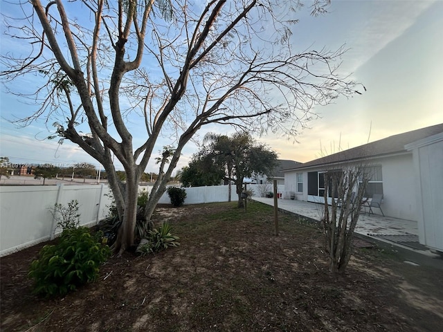 yard at dusk with a patio area