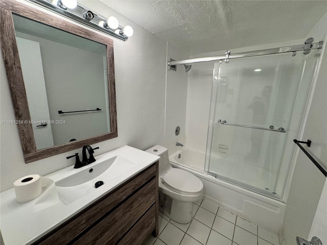 full bathroom featuring shower / bath combination with glass door, vanity, a textured ceiling, tile patterned flooring, and toilet