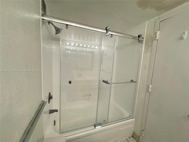 bathroom with shower / bath combination with glass door