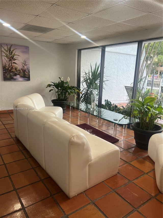 tiled living room featuring a drop ceiling