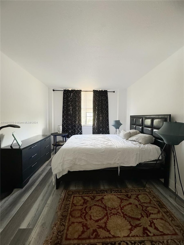 bedroom with dark hardwood / wood-style flooring