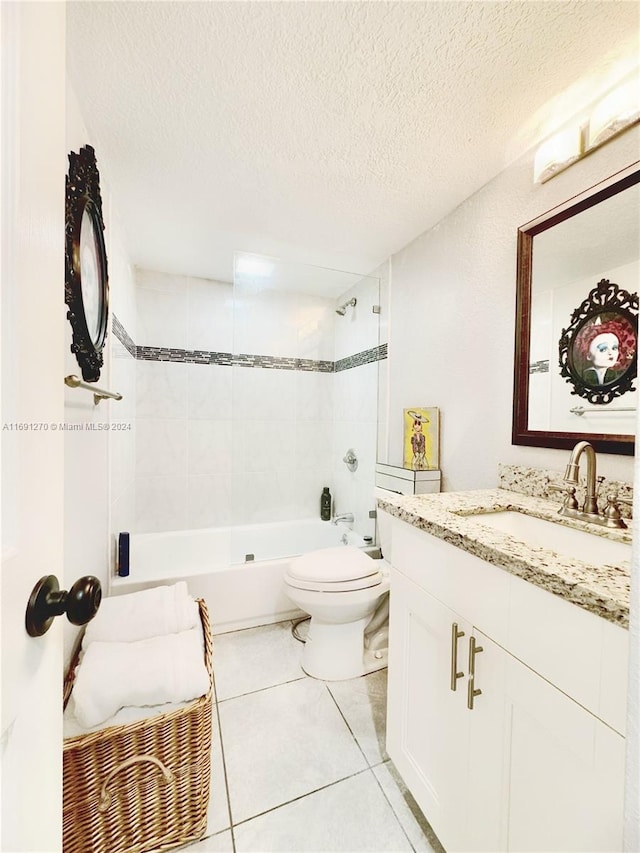 full bathroom featuring toilet, vanity, a textured ceiling, and tile patterned flooring