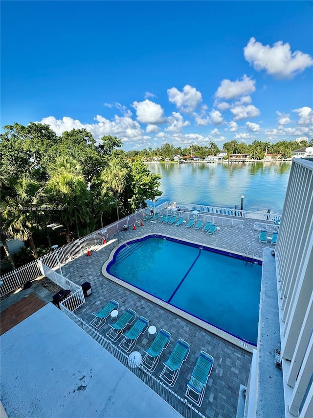 view of pool with a patio area and a water view