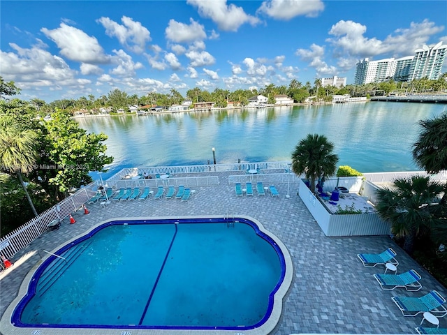 view of swimming pool featuring a patio and a water view