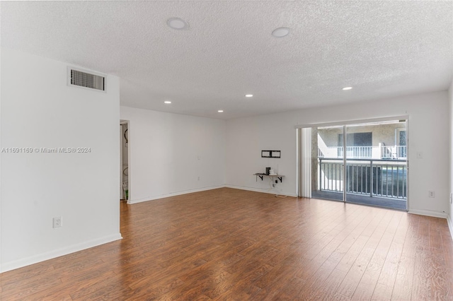 spare room with hardwood / wood-style floors and a textured ceiling