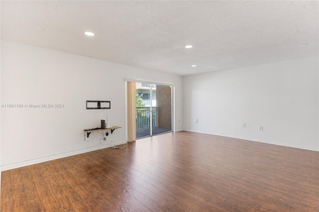 unfurnished room featuring hardwood / wood-style floors and a textured ceiling