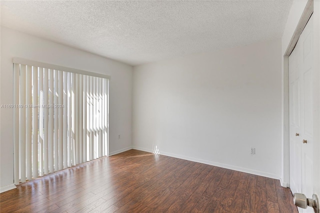 empty room featuring wood-type flooring and a textured ceiling