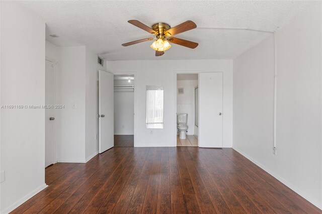 empty room with dark hardwood / wood-style flooring, a textured ceiling, and ceiling fan