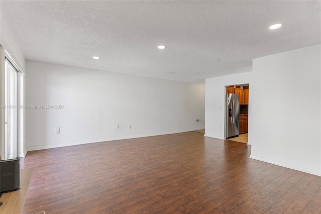 unfurnished room with dark hardwood / wood-style flooring and a textured ceiling