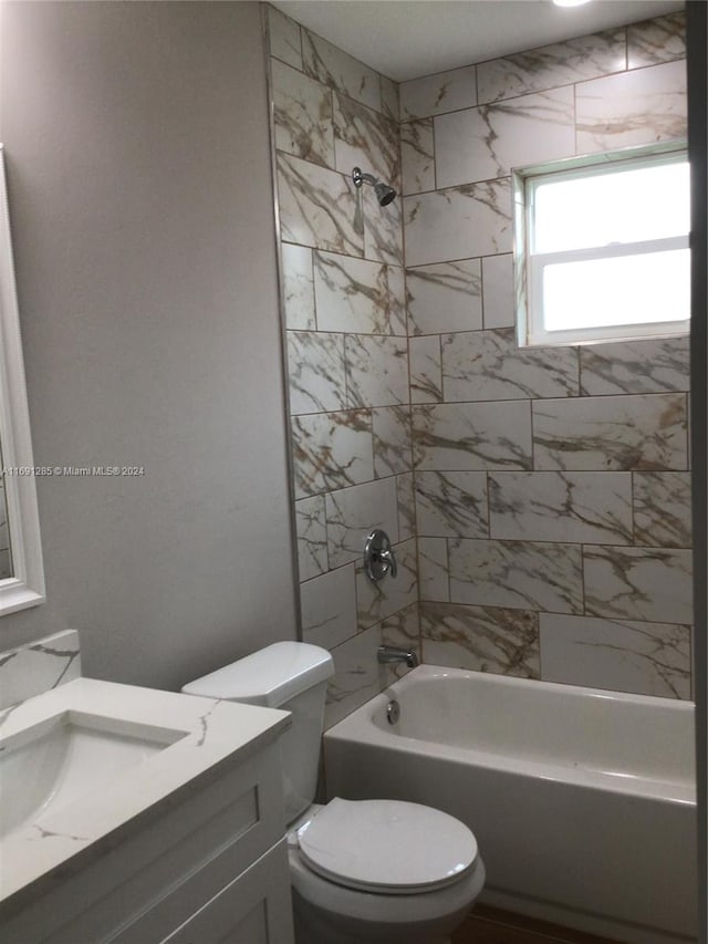 full bathroom featuring vanity, toilet, and tiled shower / bath