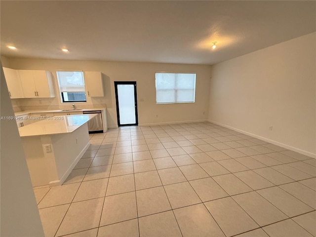 kitchen with stainless steel dishwasher, recessed lighting, light countertops, white cabinets, and a sink