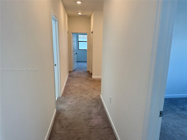 hallway with baseboards and carpet flooring