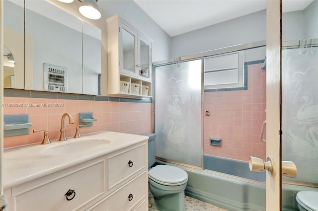 full bathroom with tile walls, enclosed tub / shower combo, vanity, decorative backsplash, and toilet