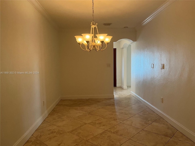 spare room featuring a chandelier and crown molding