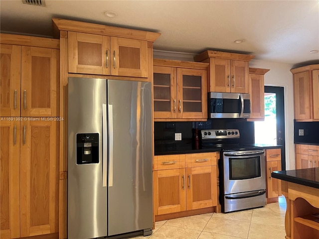 kitchen with light tile patterned flooring, appliances with stainless steel finishes, and tasteful backsplash