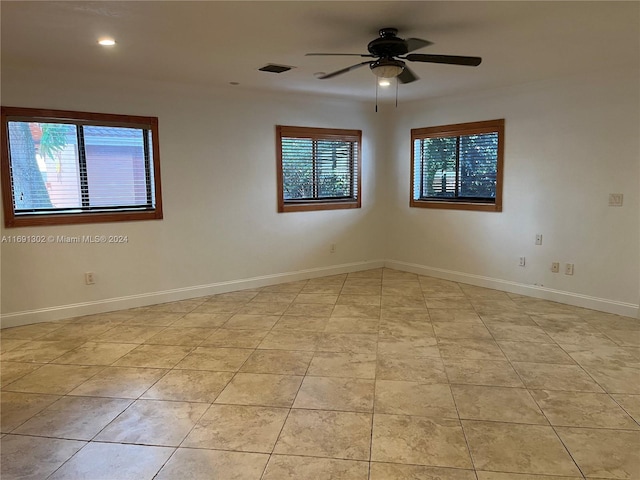 tiled spare room with a wealth of natural light and ceiling fan