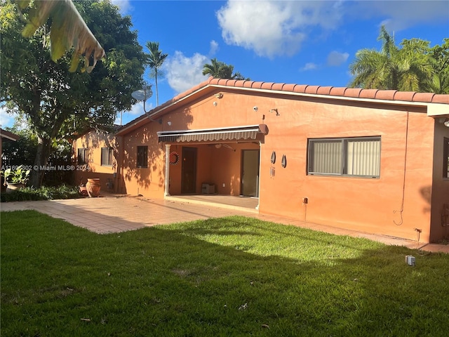 back of house with a yard and a patio area