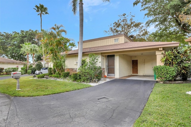 single story home featuring a carport and a front lawn