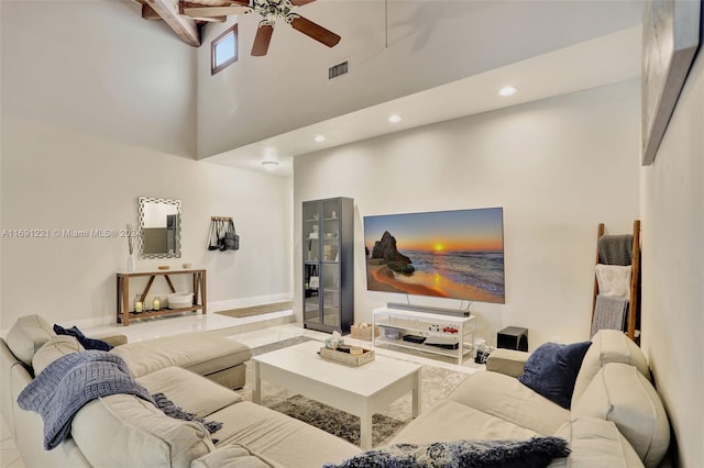 living room featuring tile patterned flooring, ceiling fan, and a high ceiling