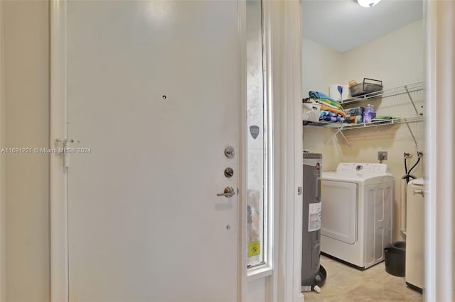 clothes washing area featuring washer / dryer and water heater