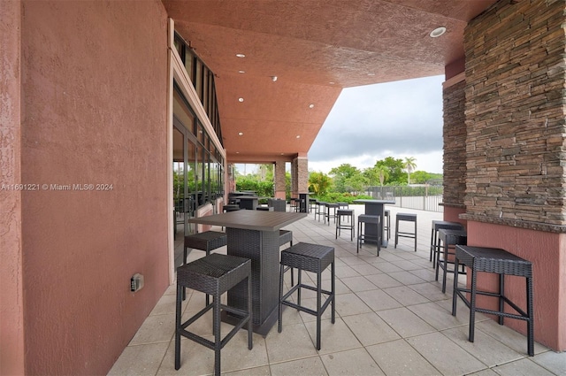 view of patio featuring exterior bar and a water view